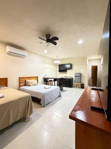 a bedroom with two beds and a ceiling fan at Miriam Lofts in Bacalar