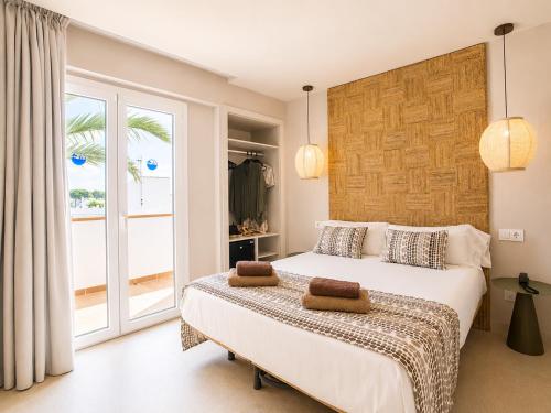 a bedroom with a bed and a large window at Hotel Ses Puntetes in Cala d´Or