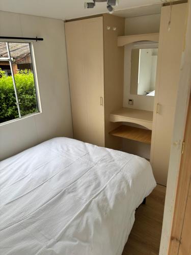 a bedroom with a white bed and a window at Mobilhomme in Brêmes