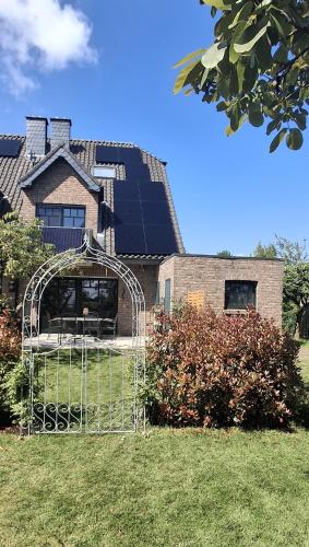 a house with an arbor in front of a building at Haus Biber - altersgerechtes Ferienhaus am Niederrhein - in Sonsbeck