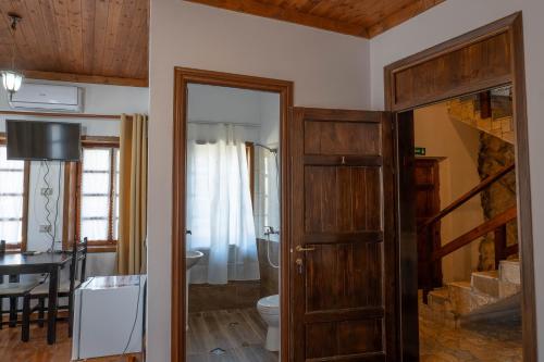 a room with a door leading to a bathroom with a table at Hotel Demaj in Berat