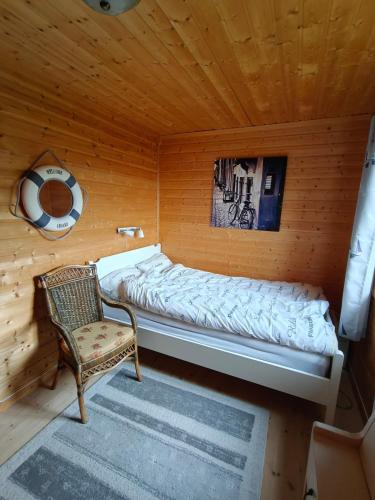 a bed in a room with a chair in a cabin at Hytte Lødingen Vestbygd, når Lofoten, med utsikt in Lødingen