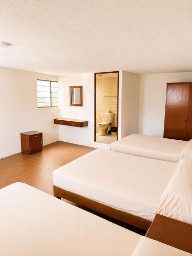 a hotel room with two beds and a bathroom at Hotel Bartolomé in Oaxaca City