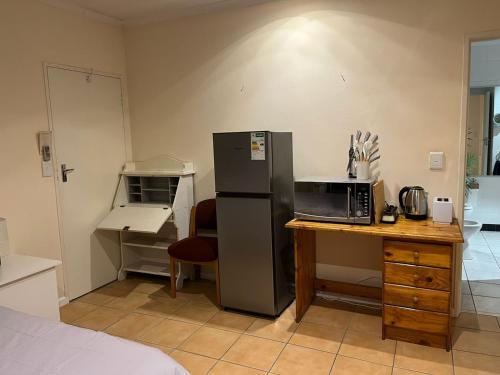 a kitchen with a refrigerator and a desk with a microwave at Adorable Pool Side Apartment in Monte Vista