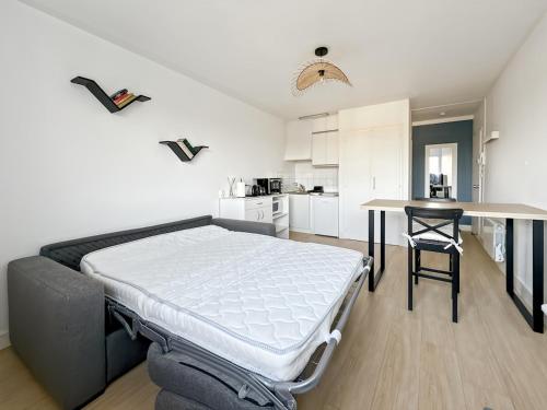 a bedroom with a bed and a table in it at Studio entre mer et forêt in Saint-Jean-de-Monts