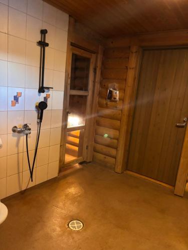 an empty room with a door and a shower at Kalliorinteen Mökit Suvipirtti in Töysä