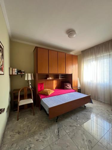 a bedroom with a large bed and a chair at Casa Ada in Termoli