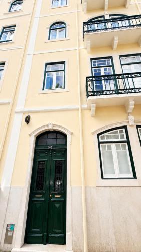 a green door on the side of a building at Avenidas Prime Lisbon in Lisbon