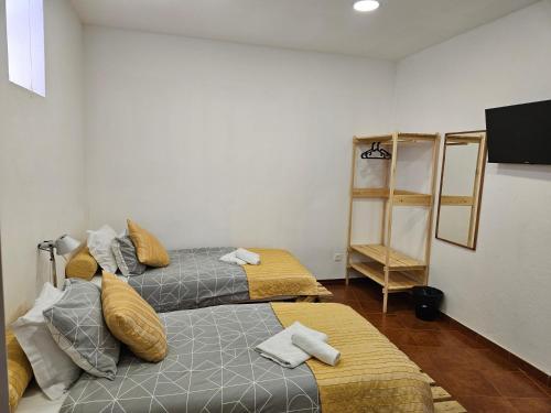 a room with two beds and a television in it at Zabava Sacavém in Sacavém