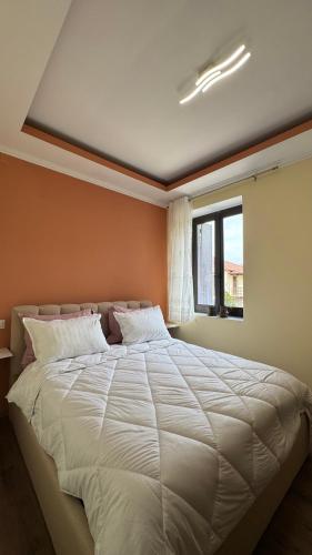 a bedroom with a large white bed with a window at Αρχοντικό Κάτω Βρύση in Levidi