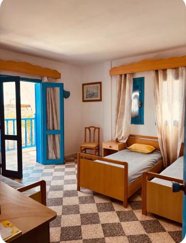 a bedroom with two beds and a table at Résidence 3 M in Jāmi‘ al Guelloufi