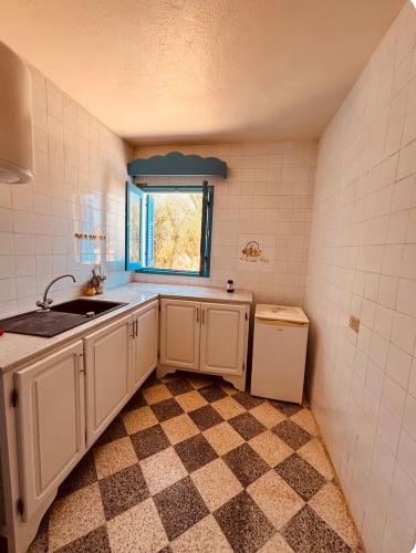 a small kitchen with a sink and a window at Résidence 3 M in Jāmi‘ al Guelloufi
