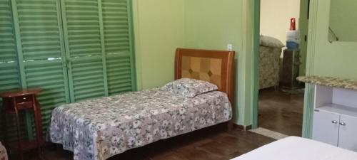 a small bed in a room with green walls at hospedagem quarto suite n1 casa da wal in Goiás