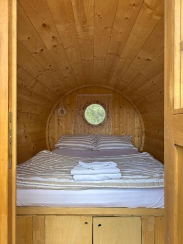 a bed in a wooden room with a window at Kucica in Lukavac