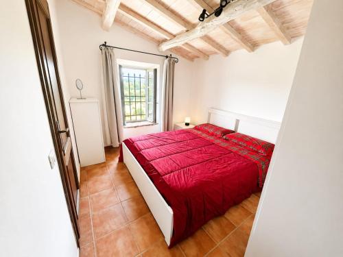 a bedroom with a red bed and a window at IN THE HILLS NEAR THE LAKE, Relax e Comfort in Grotte di Castro