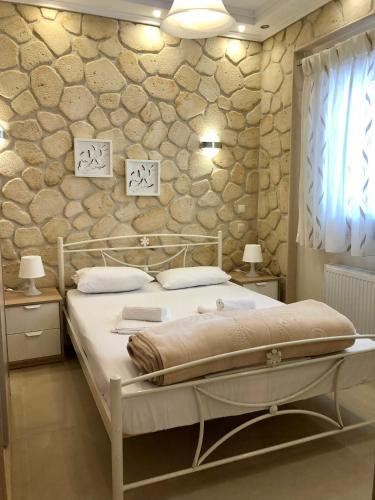 a bedroom with a bed and a stone wall at Thalassa in Siviri