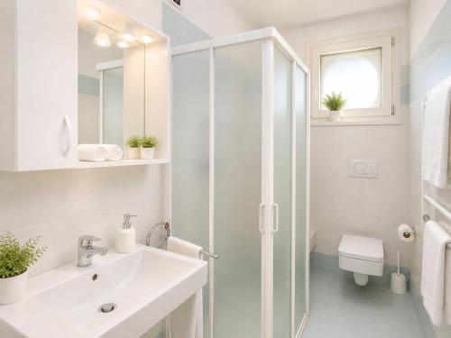 un bagno bianco con lavandino e doccia di Residence Gianka - Agenzia Cocal a Caorle
