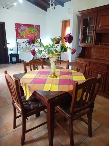 a dining room table with a vase of flowers on it at Momon1616 Intero Chalet in Galatina