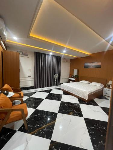 a bedroom with a bed and a black and white checkered floor at Tôm Tít Homestay in Phú Quốc