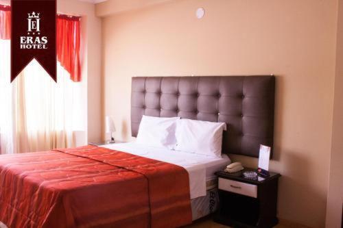 a bedroom with a large bed with a red blanket at Eras Hotel in Chiclayo