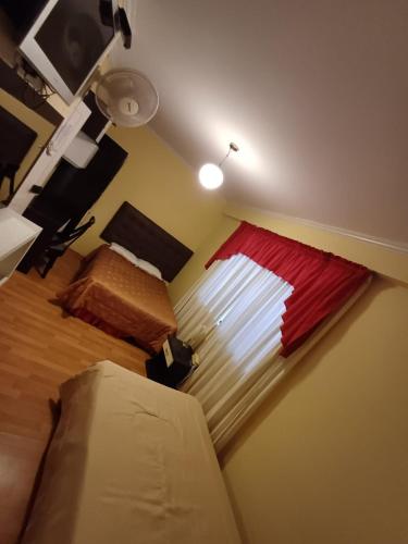 a room with a bed and a red window at Eras Hotel in Chiclayo