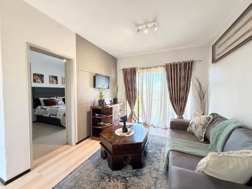 a living room with a couch and a bed at Broadacres apartment-work or play -swimming pool in Sandton