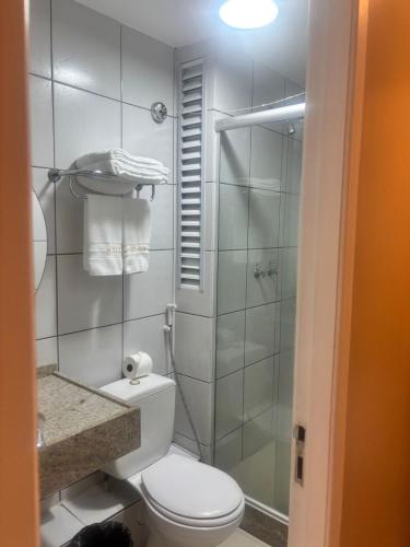a bathroom with a toilet and a glass shower at Gran Lençóis Flat - Barreirinhas -MA in Barreirinhas