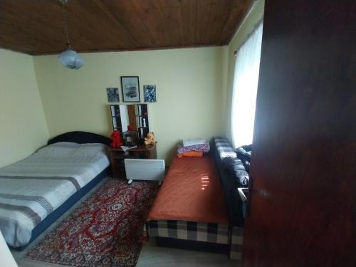 a bedroom with a bed and a couch and a window at Seoski raj in Podgorica
