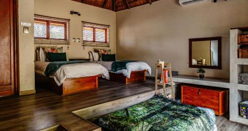 a bedroom with two beds and a mirror at Mabalingwe Nature Reserve - Elephant Lodge - Tjaila in Warmbaths