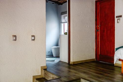 a room with a red door and a bathroom at Mabalingwe Nature Reserve - Elephant Lodge - Tjaila in Warmbaths