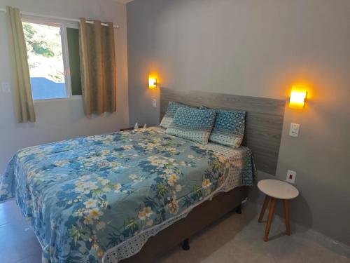a bedroom with a bed and a table and a window at Casa Bananeiras Azul in Bananeiras