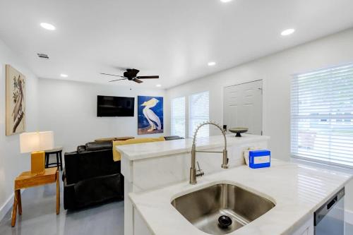 a kitchen with a sink and a living room at Peaceful Horizons at The Heron's Rest in Biloxi