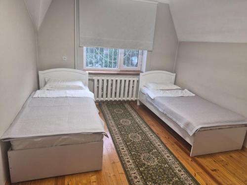 two beds in a small room with a window at Stay Osh in Osh