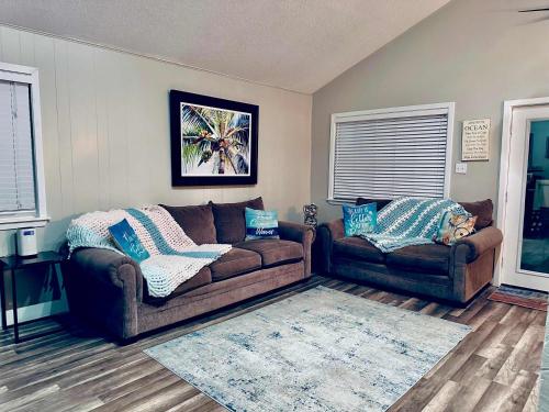 a living room with a brown couch and two couches at Bailey Beach House Beach Views in Freeport