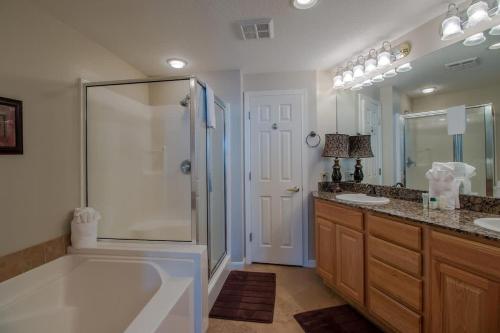 a bathroom with a tub and a shower and two sinks at Legacy Tower I in Gulfport
