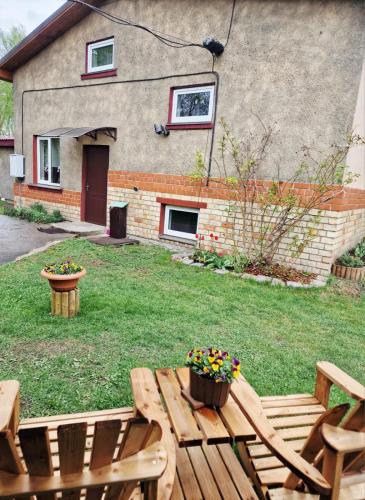 a backyard with a wooden table and chairs and a house at Brīvdienu māja Vecdaugavā in Riga