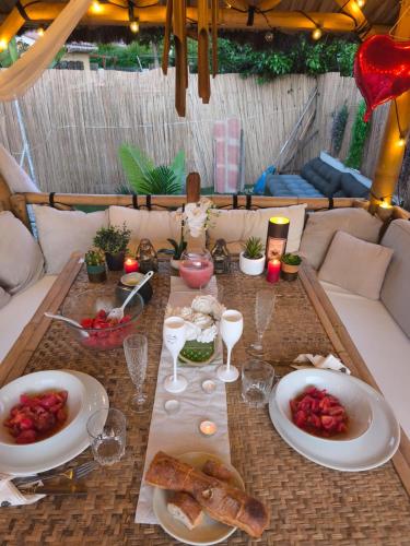 a table with plates of food and wine glasses at Le Frais Jus in Fréjus