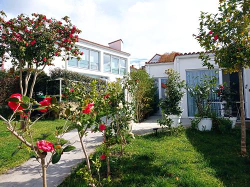 a garden with roses in front of a house at LAR JARDÍN - Casas independientes con jardín y parking privado in Santiago de Compostela