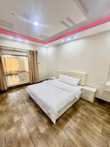 a bedroom with a white bed and a window at Chalets Zara شاليهات زارا in Taif