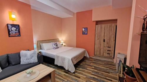 ein kleines Zimmer mit einem Bett und einer Couch in der Unterkunft Уютно Централно Студио Враца in Vratsa
