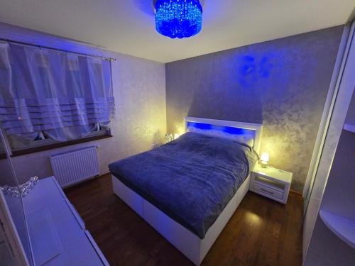 a bedroom with a bed with blue lights on it at Silent Apartment Płock in Płock