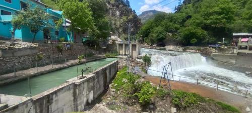a waterfall in the middle of a river at The Cozy Cottage in Kundālshai