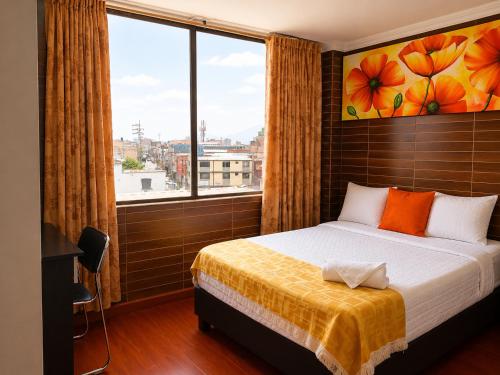a bedroom with a bed and a large window at Hotel Ejecutivo 63 In in Bogotá