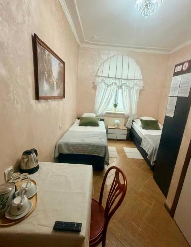 a small room with two beds and a table with a table sidx sidx at IDEAL in Płock