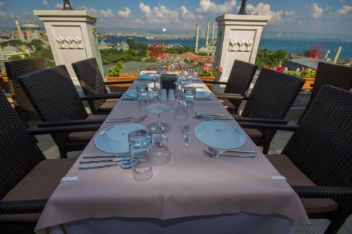 a long table with plates and wine glasses on a balcony at Deluxe Golden Horn Sultanahmet Hotel in Istanbul