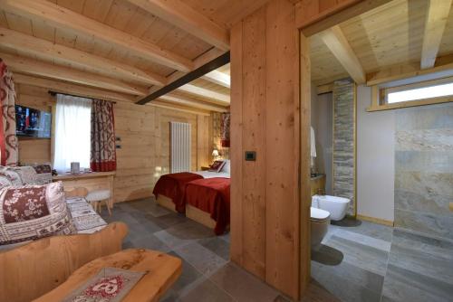 ein Schlafzimmer in einem Blockhaus mit einem Bett und einem Sofa in der Unterkunft Il Cuore Del Cervino in Breuil-Cervinia