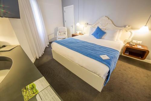 een slaapkamer met een groot bed met een blauw kussen bij Hotel Beyond in Izmir