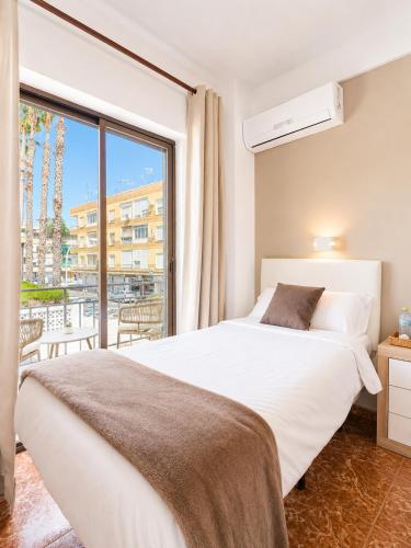 a bedroom with a bed and a large window at Pensión Rocamar in Almuñécar
