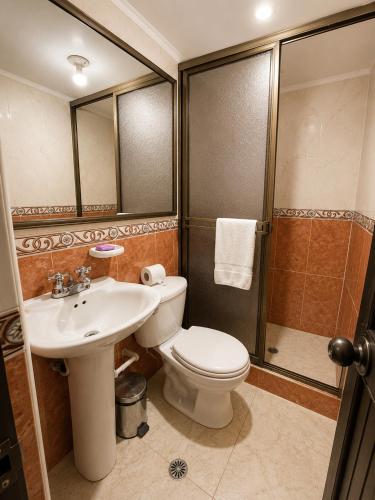 a bathroom with a toilet and a sink and a shower at Hotel Ejecutivo 63 In in Bogotá