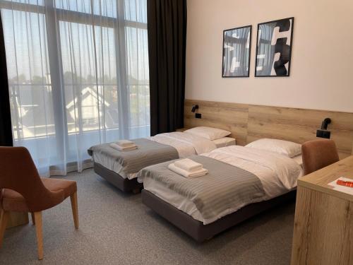 a hotel room with two beds and a window at Soccer Box Pro in Dachnów